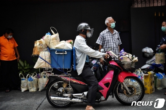 2일 태국 방콕 빈민 지역에 식품 등 물자를 배송하는 자원봉사자들. © AFP=뉴스1