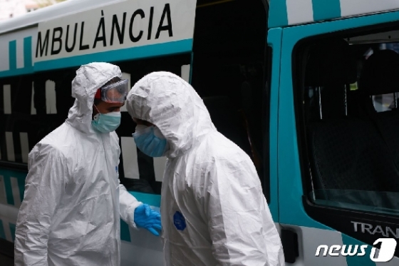 신종 코로나바이러스 감염증(코로나19) 경증 환자를 치료하는 스페인 바르셀로나 한 호텔 앞에 있는 의료 관계자들. © AFP=뉴스1