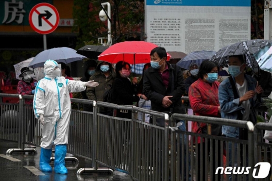 (황강 AFP=뉴스1) 26일(현지시간) 후베이성 황강 병원의 발열 클리닉에서 검사를 받으려는 주민들이 줄을 서 있다.   ⓒ AFP=뉴스1