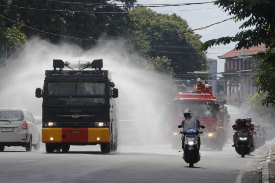 [발리=AP/뉴시스]31일(현지시간) 인도네시아 발리에서 경찰이 물대포 차량을 이용해 신종 코로나바이러스 감염증(코로나19)이 발생할 우려가 있는 공공도로에 소독약을 뿌리고 있다. 인도네시아의 코로나19 확진자는 30일 기준 1414명, 사망자는 122명으로 집계됐다. 2020.03.31.