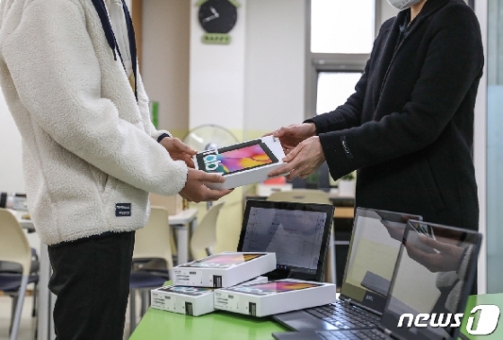 '온라인 개학'을 하루 앞둔 지난 8일 서울의 한 중학교에서 학생이 태블릿PC를 지급받고 있다. /뉴스1 © News1 박종홍 기자