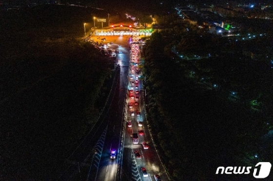 8일(현지시간) 코로나19 진원지로 76일만에 봉쇄령이 해제된 후베이성 우한의 고속도로 톨게이트에 차량들이 길게 줄을 서 있다. © AFP=뉴스1 © News1 우동명 기자