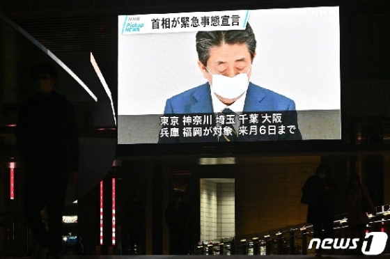 아베 신조 일본 총리의 지난 7일 코로나19 관련 '긴급사태 선언' 기자회견이 도쿄시내 대형 전광판을 통해 방송되고 있다. © AFP=뉴스1