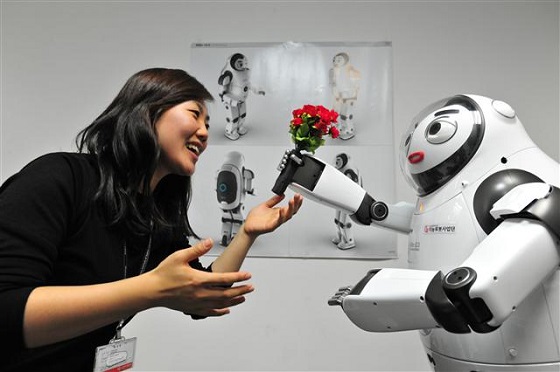 한국과학기술연구원의 휴머노이드(인간형 로봇) 키보(오른쪽)가 여성 연구원에게 꽃을 전달하며 수줍은 표정을 짓고 있다/자료사진=KIST