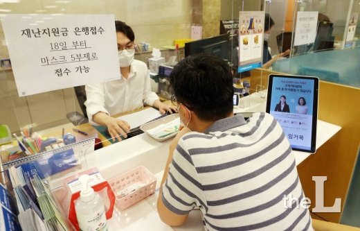 정부 긴급재난지원금 현장 신청 첫 날인 18일 오전 서울 중구 우리은행 을지로지점에서 시민들이 상담을 받고 있다.