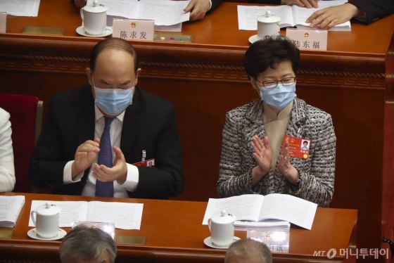 [베이징=AP/뉴시스]5월22일(현지시간) 중국 베이징 인민대회당에서 중국 최대 정치 행사인 전국인민대표회의(전인대)가 열리고 있는 가운데 캐리 람 홍콩 행정장관(오른쪽)이 신종 코로나바이러스 감염증(코로나19)을 막기 위해 마스크를 쓴 채 박수를 치고 있다.  2020.05.22.