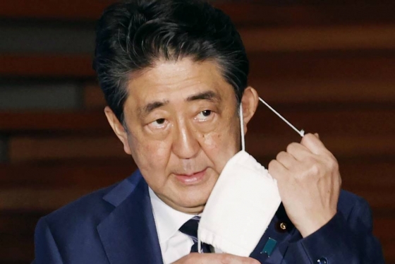 [도쿄=AP/뉴시스]아베 신조 일본 총리가 21일 기자회견에서 마스크를 벗고 있다. 일본 정부는 이날 3개 지역에 대해 긴급사태 선언 추가 해제를 발표했다. 도쿄 등 5개 지역에 대해서는 오는 25일 다시 검토하겠다고 밝혔다. 2020.05.22.