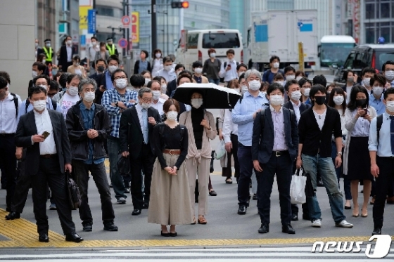 T26일 일본 도쿄에서 마스크를 착용한 시민들이 횡단보도 앞에 서 있다. © AFP=뉴스1