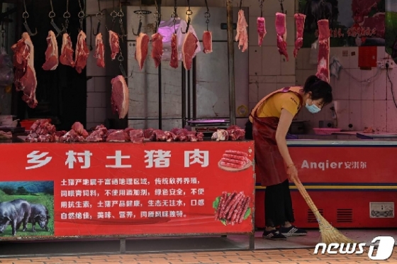 지난 21일 중국 후베이성 우한에 있는 한 정육점에서 종업원이 가게 청소를 하고 있다. © AFP=뉴스1