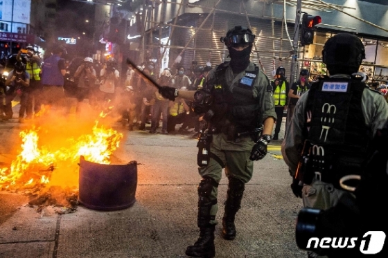 27일 홍콩 시위대가 길거리에 불을 놓자 경찰이 출동해 현장을 통제하고 있다. © AFP=뉴스1