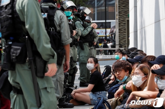 27일 홍콩 코즈웨이베이 역에서 시위를 벌인 시민들을 경찰들이 체포해 감시하고 있다. © 로이터=뉴스1