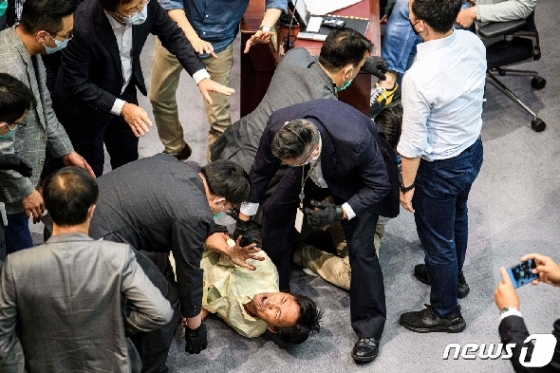 18일 (현지시간) 홍콩 입법회에서 핵심 위원회 위원장 선임 문제를 놓고 실랑이를 벌인 야당인 범민주파 의원이 보안요원들에 둘러싸여 있다. © AFP=뉴스1 © News1 우동명 기자
