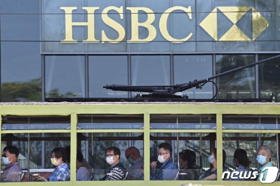 지난 4월28일 마스크를 쓴 통근자들이 트램을 타고 HSBC은행 앞을 지나고 있다. © AFP=뉴스1
