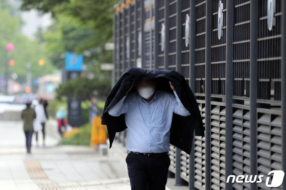 (서울=뉴스1) 이재명 기자 = 비가 내린 28일 오전 서울 종로구 정부서울청사 인근 거리에서 우산을 준비하지 못한 시민들이 발걸음을 재촉하고 있다.  기상청은 이날 우리나라는 북한을 지나는 기압골의 영향을 받아 오전부터 밤 사이 비 또는 소나기가 내리는 곳이 있다고 전망했다. 2020.5.28/뉴스1