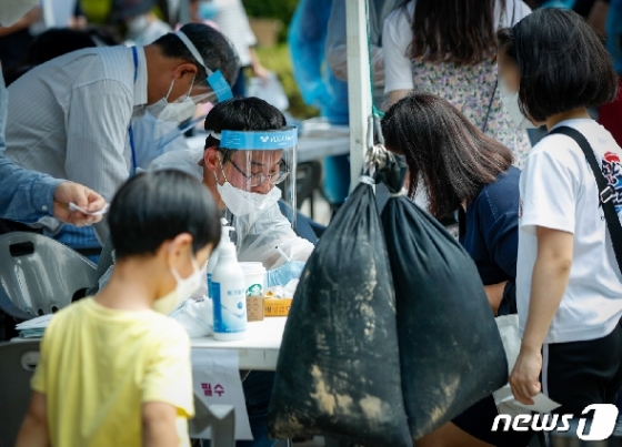 지난달 30일 서울 영등포구 자매근린공원 현장선별진료소에서 의료진이 문진을 하고 있다. /뉴스1 © News1 안은나 기자