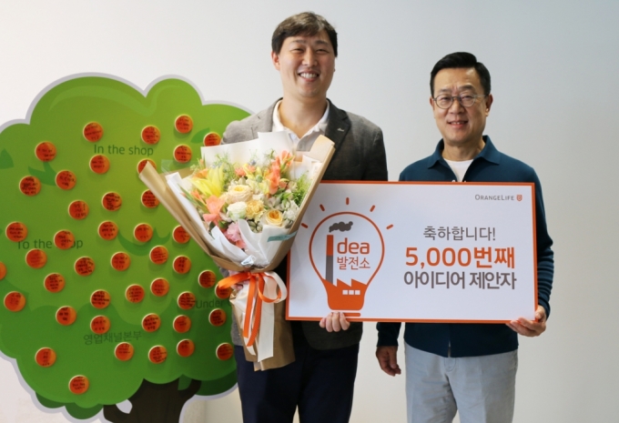 서울 중구 순화동 오렌지센터에서 5000번째 아이디어를 제안한 오렌지라이프 직원과 정문국 사장(오른쪽)이 기념촬영을 하고 있다. /사진=오렌지라이프