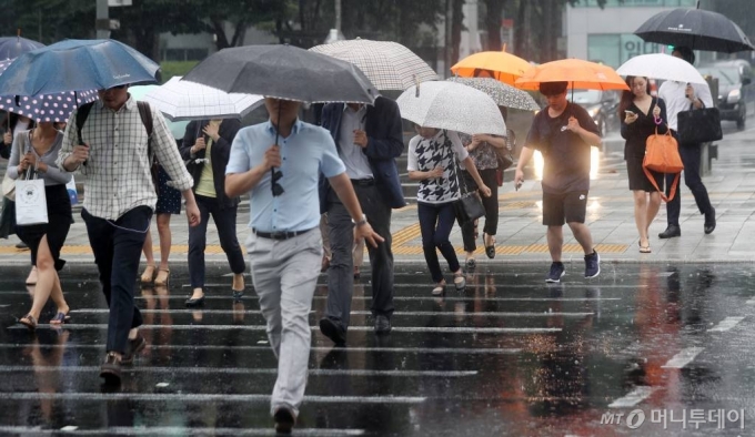 전국 장마가 시작된 지난해 6월26일 오전 서울 광화문네거리에 시민들이 우산을 쓴 채 발걸음을 옮기고 있다. / 사진=김휘선 기자 hwijpg@