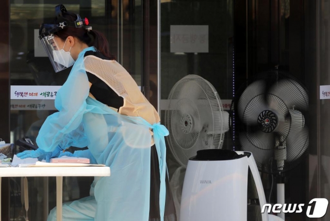 (서울=뉴스1) 구윤성 기자 = 무더위가 이어지고 있는 15일 오후 서울 중랑구 보건소에 마련된 신종 코로나바이러스 감염증(코로나19) 선별진료소에서 의료진이 선풍기와 아이스조끼 등으로 더위를 식히며 업무를 보고 있다. 2020.6.15/뉴스1