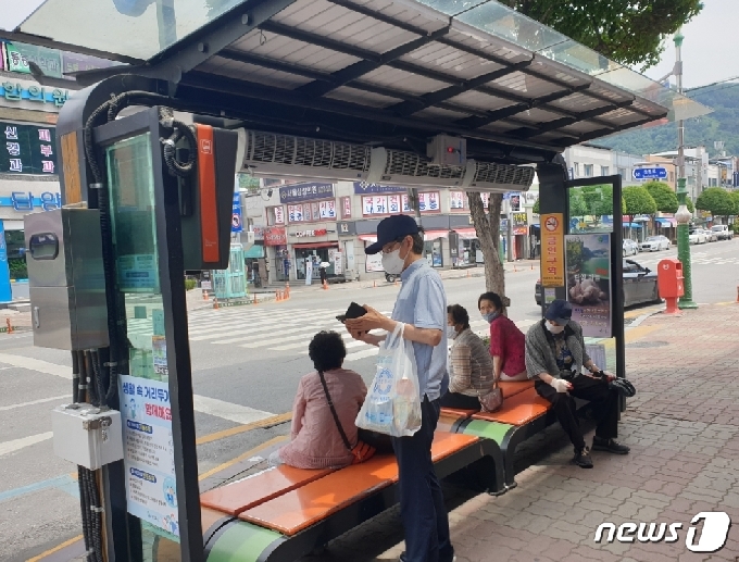 단양읍 시내버스 정류장에 설치된 에어커튼 아래서 승객들이 버스를 기다리고 있다.(단양군 제공)© 뉴스1