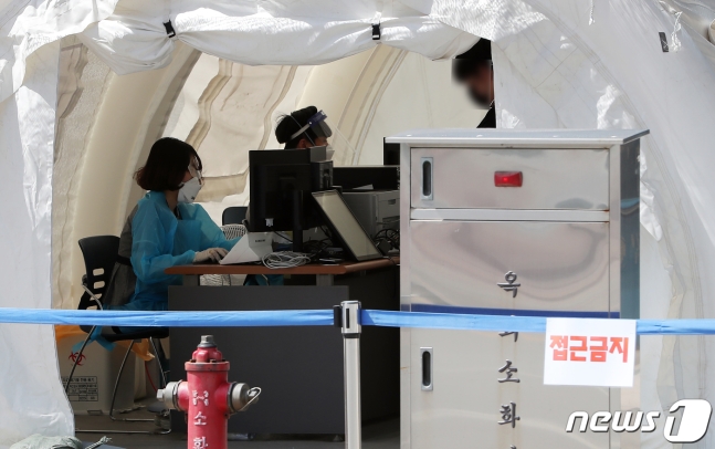 지난 15일 서울 중랑구 서울의료원 선별진료소에서 검사자가 문진표를 제출하고 있다./뉴스1 © News1