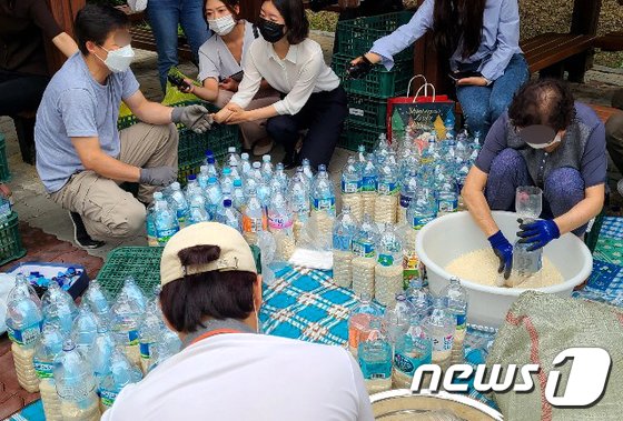탈북자 단체인 큰샘 관계자들이 지난 18일 서울 강남구 수서동의 한 공원에서 북으로 보낼 쌀을 페트병에 담고 있다.(큰샘제공)/사진=뉴스1<br>

