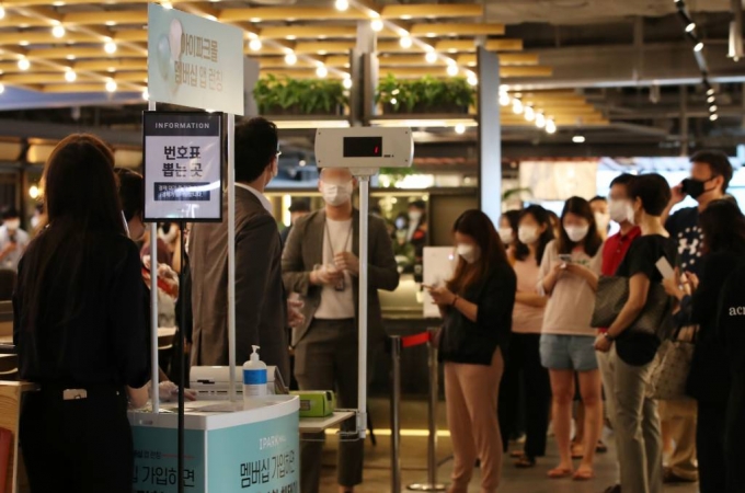 25일 서울 용산구 한강대로 신라아이파크면세점 D7 푸드씨네마에 마련된 쇼룸 앞에서 구매자들이 번호표를 뽑고 대기하고 있다./사진=뉴시스