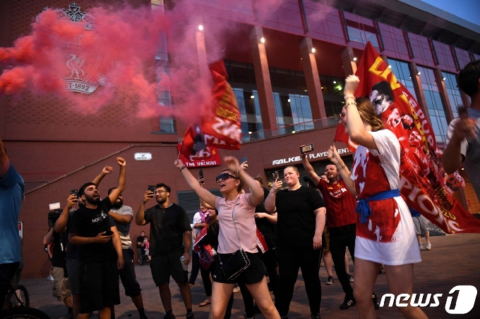 리버풀 팬들이 26일(한국시간) 잉글랜드 프리미어리그(EPL) 우승이 확정되자 홈 구장인 안필드 주변에서 축하하고 있다. © AFP=뉴스1
