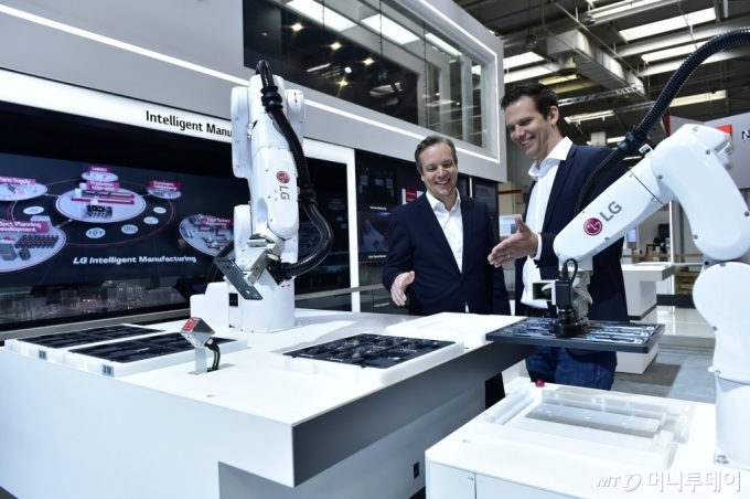 LG전자가 지난해 4월 독일 하노버에서 열린 산업기술 전시회 '하노버 메세 2019'에 처음으로 참가해 모바일매니퓰레이터 등 지능형 제조 솔루션을 공개했다. 관람객들이 모바일매니퓰레이터가 스마트폰 부품을 이송하는 모습을 살펴보고 있다. /사진제공=LG전자
