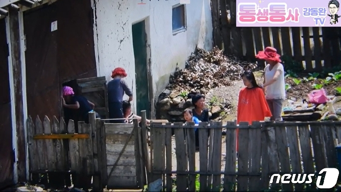 북한의 양강도 삼수군 지역 주민들이 마을 창고 뒤편에서 출장 미용 서비스를 받고 있다. ('통생통사 강동완 TV' 갈무리) © 뉴스1