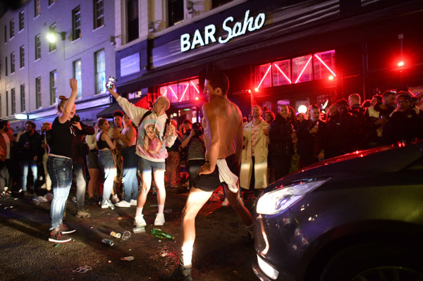 영국 런던 소호 거리에서 술에 취한 시민들이 차량 통행을 막아선 채 춤을 추고 있다/사진=AFP