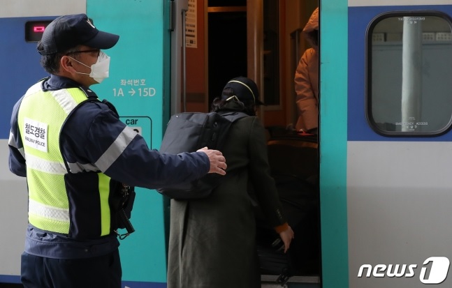 KTX 광명역에서 한 해외입국자가 철도경찰의 안내을 받아 입국인 열차 전용칸에 오르고 있다./사진=뉴스1