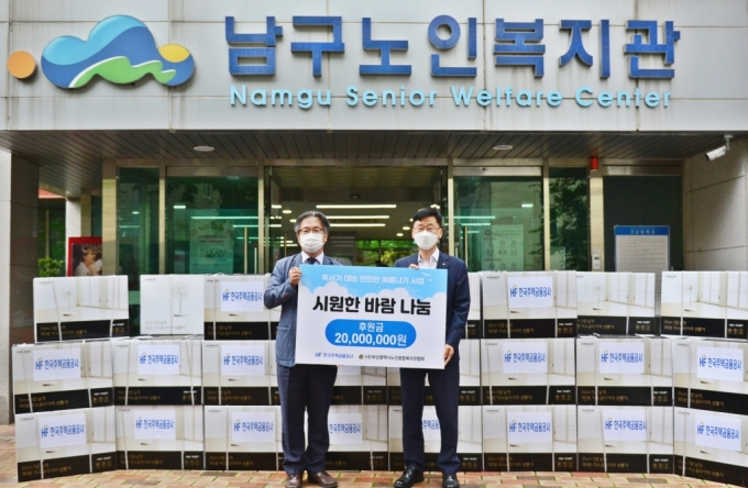 이정환 한국주택금융공사 사장(오른쪽)이 15일 박시우 부산시 노인종합복지관협회장에게 시원한 바람나눔 후원금을 전달하고 기념촬영을 하고 있다./사진제공=한국주택금융공사