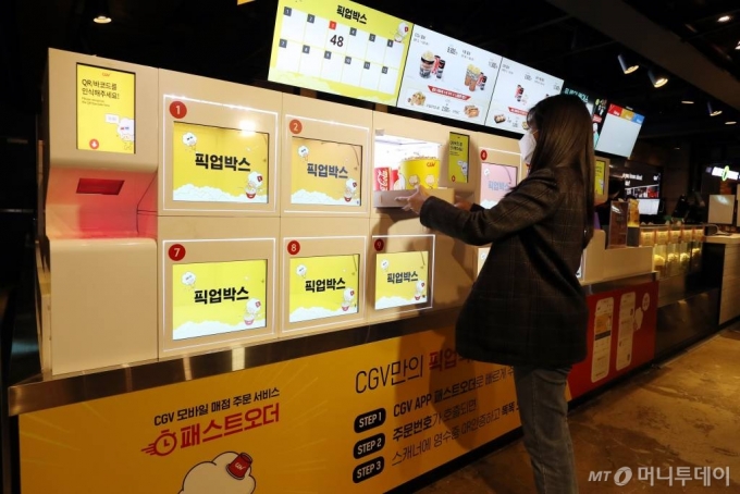 CJ CGV가 대면 서비스를 최소화한 '언택트시네마'를 선보인 가운데 21일 서울 CGV 여의도에서 한 시민이 직원과 대면 없는 '픽업박스'를 이용해 팝콘을 구매하고 있다. '언택트시네마'는 다양한 하이테크 기술을 통해 언택트(Un-tact) 서비스를 기반으로 새롭고 간편하게 극장 시설을 이용할 수 있는 서비스다. / 사진=이기범 기자 leekb@