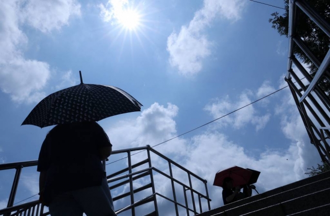 서울 용산구 한강진역 인근에서 시민들이 양산을 쓴 채 발걸음을 옮기고 있다./사진=김휘선 기자