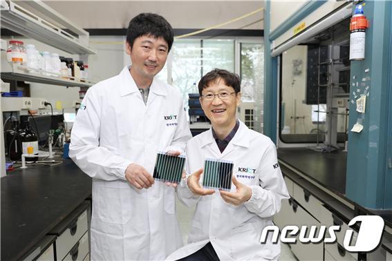 한국화학연구원 에너지소재연구센터 송창은 박사(왼쪽)와 신원석 박사가 새로 개발한 광활성 신소재가 적용된 유기태양전지를 들고 포즈를 취했다.© 뉴스1