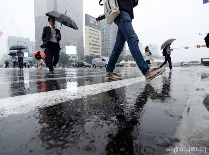 전국 장마가 시작된 26일 오전 서울 광화문네거리에 시민들이 우산을 쓴 채 발걸음을 옮기고 있다./사진=김휘선 기자