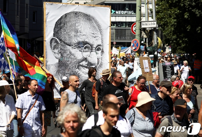 1일(현지시간) 독일 베를린에서 정부의 코로나19 규제에 항의하는 시위가 열린 가운데 시위대가 마하트마 간디의 초상화가 등장했다. © 로이터=뉴스1