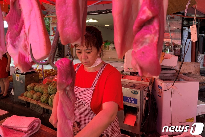 지난 6월30일 중국 후베이성 우한의 한 시장 정육점에서 판매자가 돼지고기를 손질하고 있다. © 로이터=뉴스1