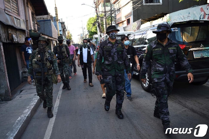필리핀 경찰이 코로나19 감염자 폭증으로  봉쇄된  필리핀 시내를  순찰 하고 있다.© AFP=뉴스1