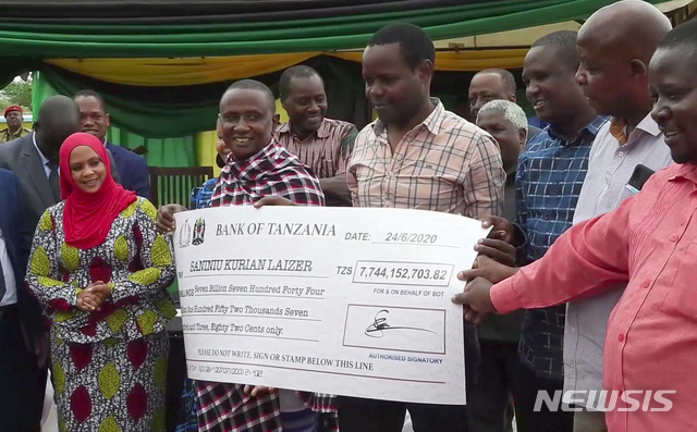 [메레라니(탄자니아)=AP/뉴시스]사니누 라이저(가운데 왼쪽)가 정부로부터 받은 77억4415만2703.82 탄자니아 실링(340만 달러) 수표를 들어보이고 있다. 2020.8.4