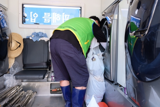 13일 오전 강원도 철원군 동송읍 이길리 마을회관 앞 삼성전자의 '온정나눔 세탁소'에서 봉사자가 빨랫감을 빼내고 있다. /사진=박소연 기자