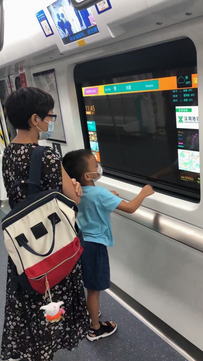 중국 심천 지하철에 설치된 LG디스플레이 55인치 투명 OLED를 승객들이 살펴보고 있다/사진제공=LGD