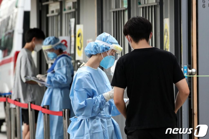 신종 코로나바이러스 감염증(코로나19) 확산세가 이어지고 있는 20일 오후 서울 성북구보건소에 마련된 선별진료소를 찾은 시민들이 검사를 위해 의료진의 설명을 듣고 있다. 2020.8.20/사진=뉴스1
