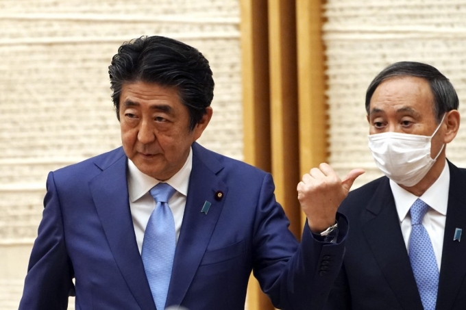 지난 28일 지병인 궤양성대장염 재발로 사임 의사를 밝힌 아베 신조 일본 총리(왼쪽)과 스가 요시히데 관방장관. /AFPBBNews=뉴스1