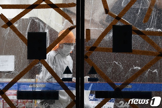 6일 일본 가고시마현 가고시마시의 한 주민이 태풍 '하이선'의 접근을 앞두고 편의점에서 물건을 구매하고 있다. 창문에는 유리창 깨짐을 방지하기 위한 테이프가 붙어 있다. © AFP=뉴스1