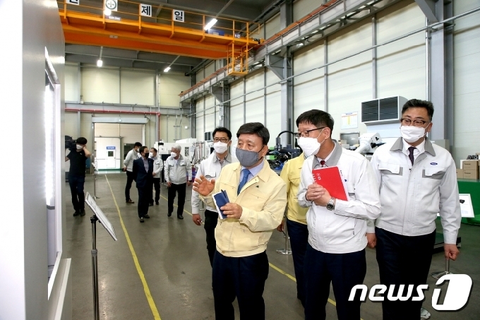 허성곤 김해시장(가운데)이 국내 기술로 마스크 생산설비를 제작하는 기업인 ㈜스맥을 방문해 시설을 살펴보고 있다. © 뉴스1