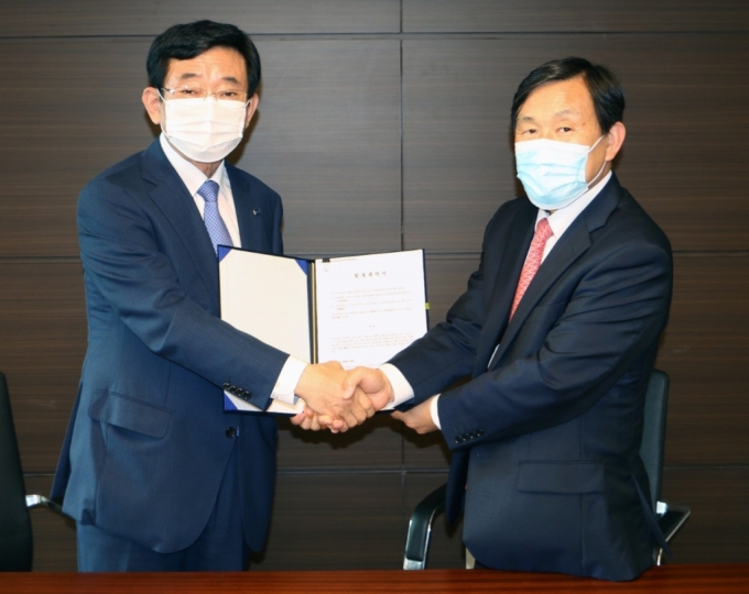 김내환 KCC글라스 대표이사(왼쪽)와 우종철 코리아오토글라스 대표이사가 9일 합병 계약을 체결하고 악수하고 있다./사진제공=KCC글라스