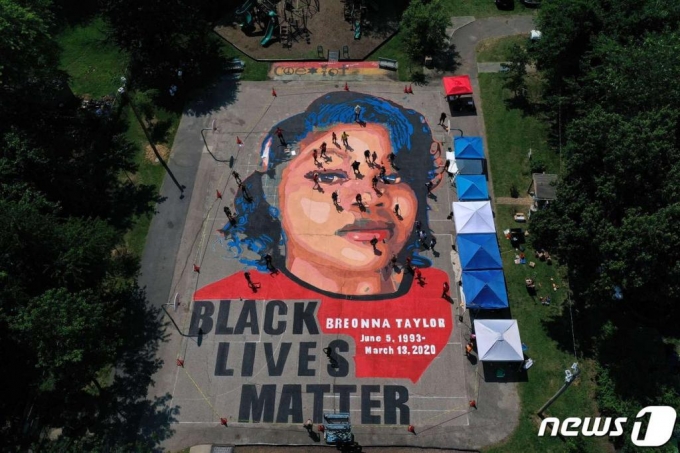 (아나폴리스 AFP=뉴스1) 지난 7월 5일(현지시간) 매릴랜드주 아나폴리스의 공원에 ‘흑인 생명도 소중하다’ 문구과 함께 경찰 총격에 숨진 흑인 여성 브리오나 테일러를 그린 거대한 바닥 벽화가 보인다.  ⓒ AFP=뉴스1