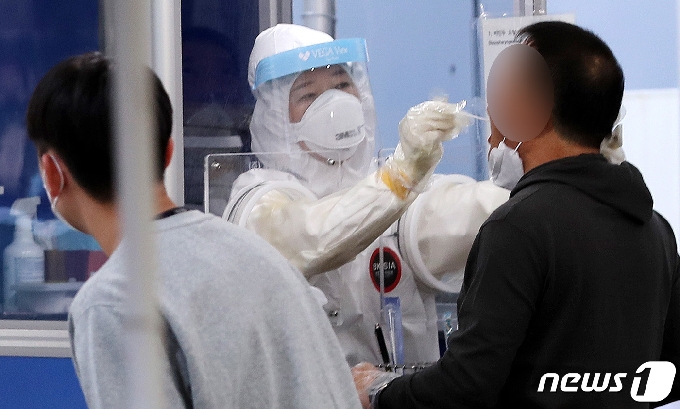 18일 서울 송파구 선별진료소에서 한 시민이 신종 코로나바이러스 감염증(코로나19) 검체 검사를 받고 있다. /뉴스1 © News1 박지혜 기자
