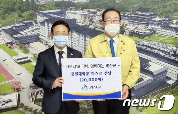 이차영 괴산군수(왼쪽)가 김두년 중원대 총장에게 마스크를 전달하고 있다.(괴산군 제공)© 뉴스1